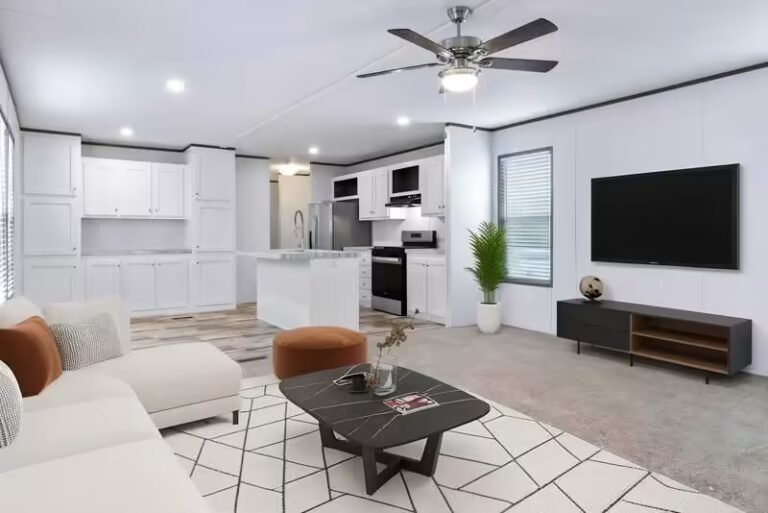 Modern open-concept living room with sectional couch, coffee table, wall-mounted area rug, and flat-screen TV near an