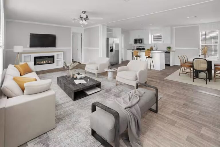 Bright open-concept living room with cream sectional sofa, tufted ottoman, and hardwood floors.